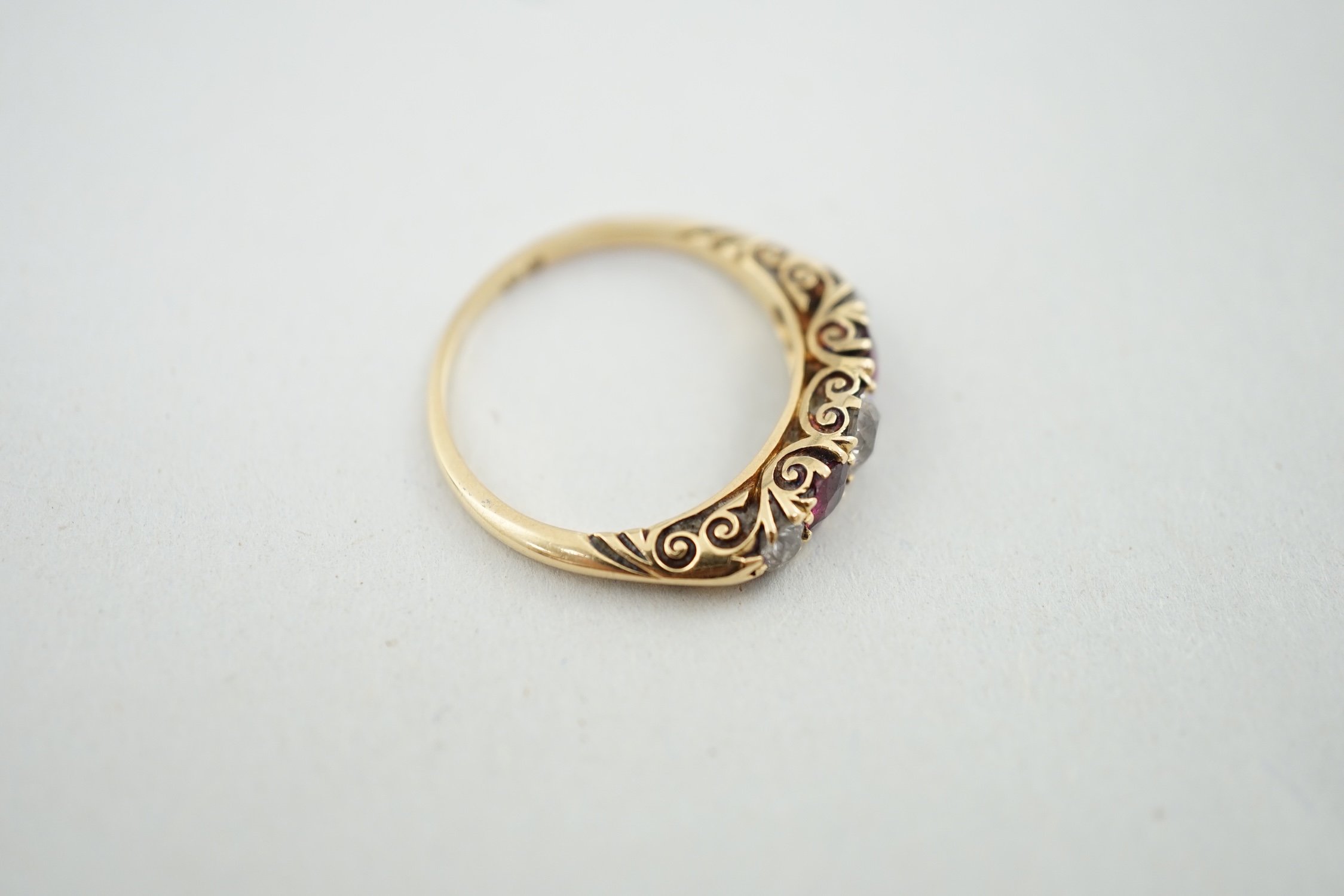 A late Victorian gold, three stone diamond and two stone ruby set half hoop ring